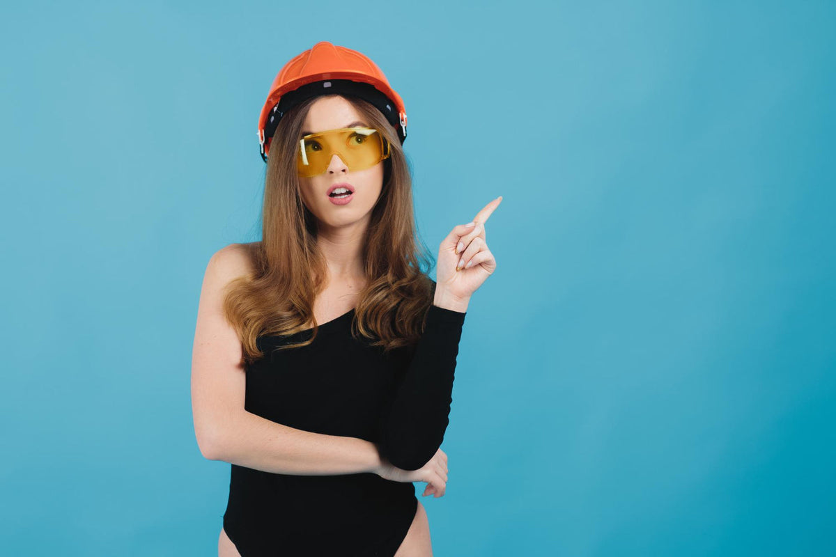 Woman wearing orange hard had with safety glasses 