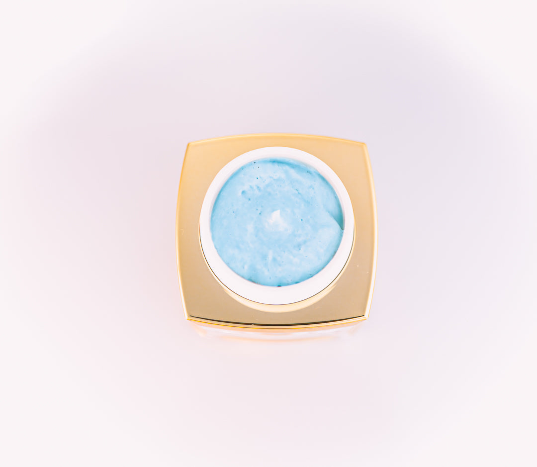 Cosmetic cream in a gold container on a light pink background