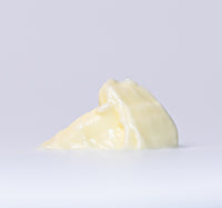 Melted white chocolate on a light gray background